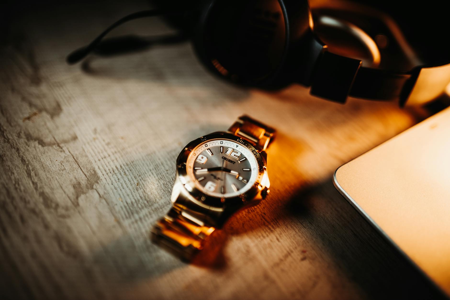 Close-up of a vintage analog watch on a wooden table with warm lighting.