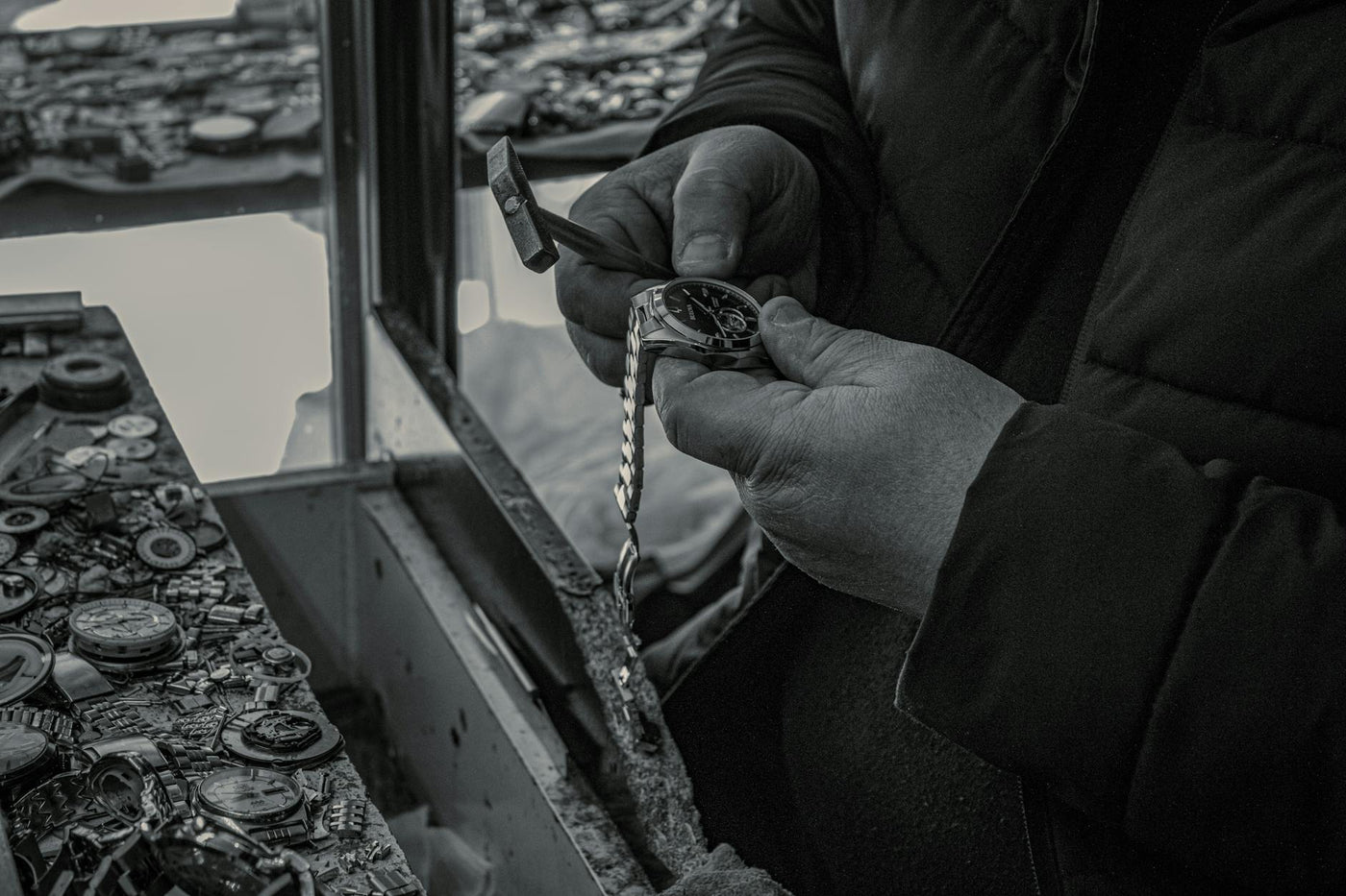 A watchmaker skillfully repairs a watch at a workshop, focusing on intricate details.