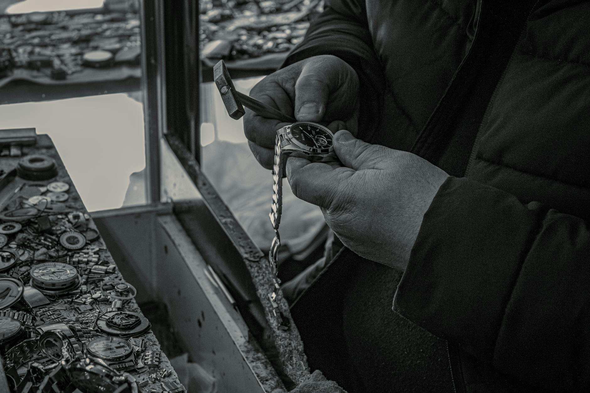 A watchmaker skillfully repairs a watch at a workshop, focusing on intricate details.