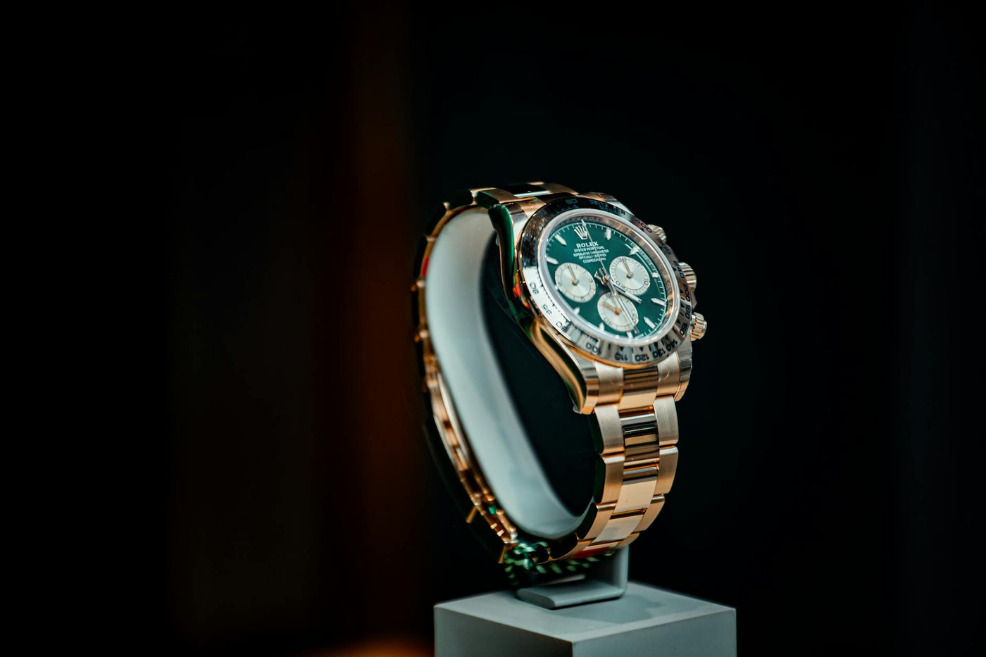 Stunning emerald green and gold luxury watch displayed elegantly against a dark background.