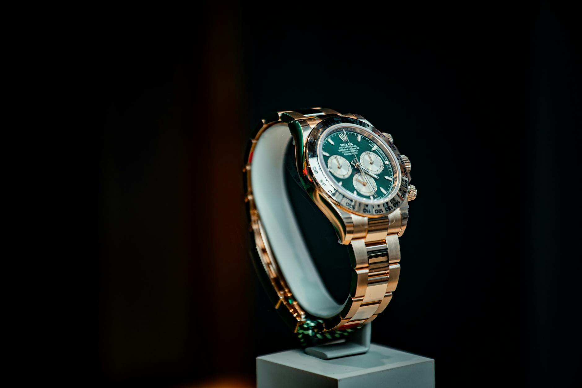 Stunning emerald green and gold luxury watch displayed elegantly against a dark background.