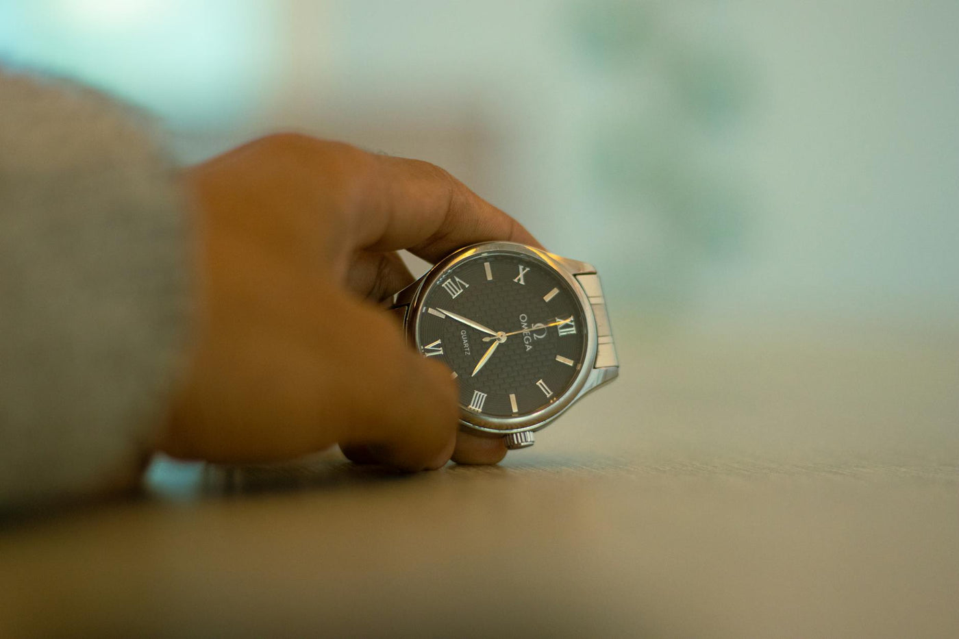 Detailed close-up shot of a luxury wristwatch held by a hand, showcasing elegance.