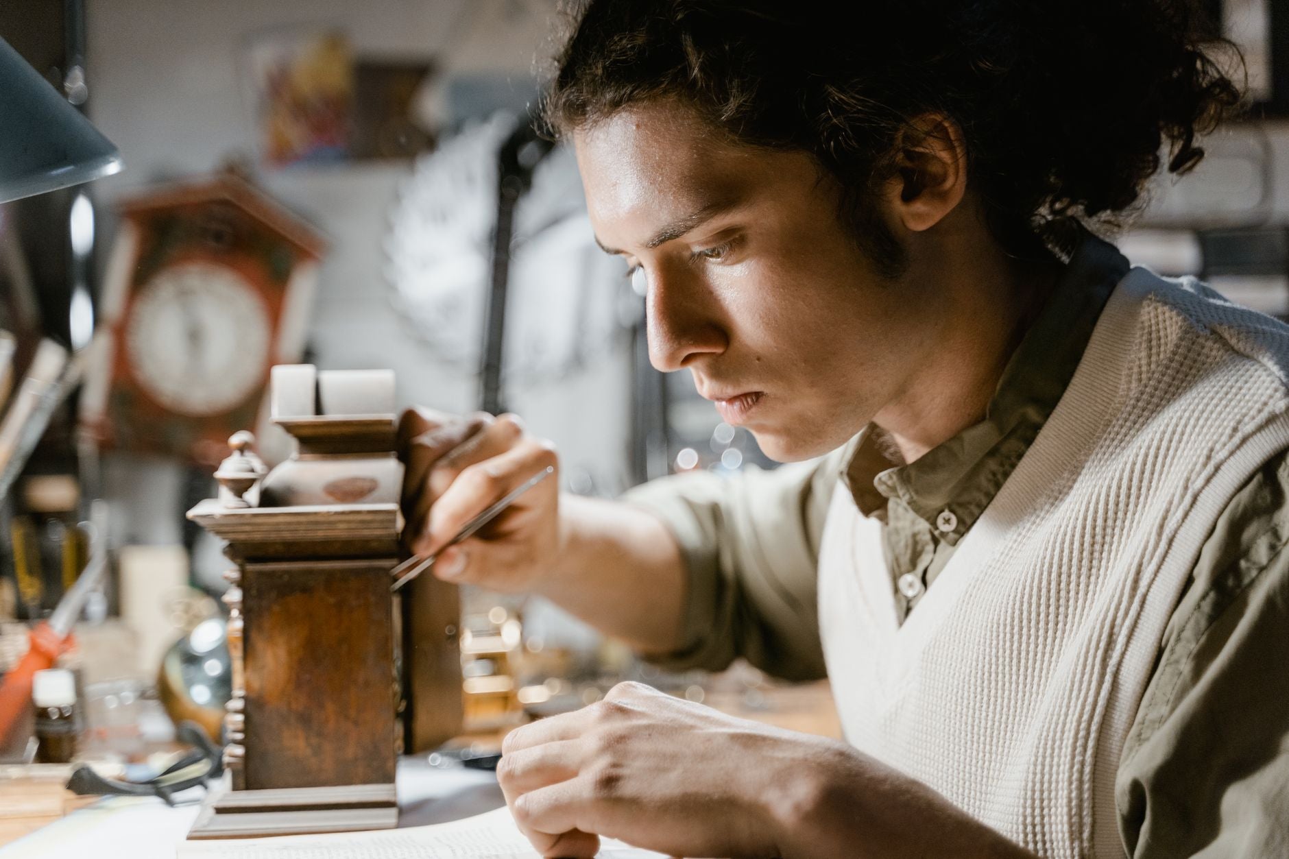Close-up of a male watchmaker meticulously repairing a vintage timepiece indoors.