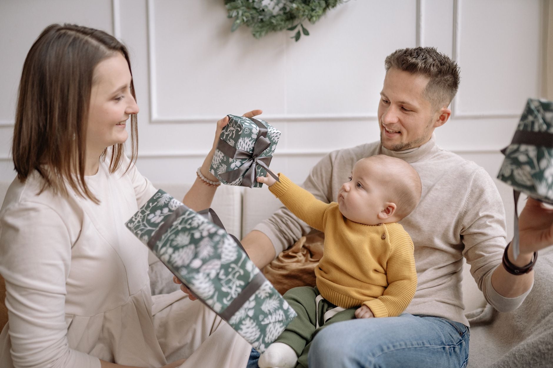 A joyful family exchanging Christmas presents while bonding indoors.