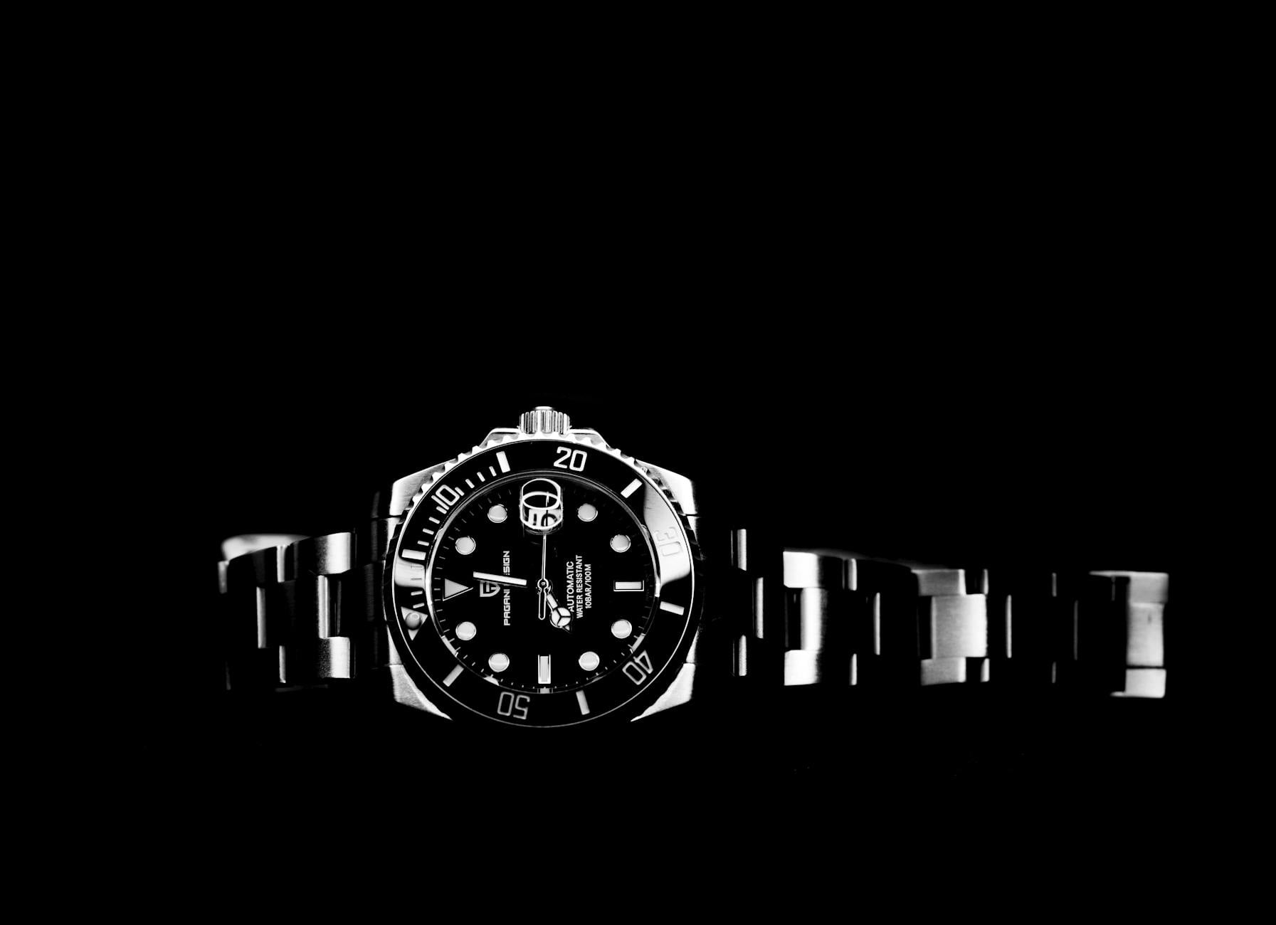 Black and white close-up of an elegant wristwatch with detailed timepiece features.