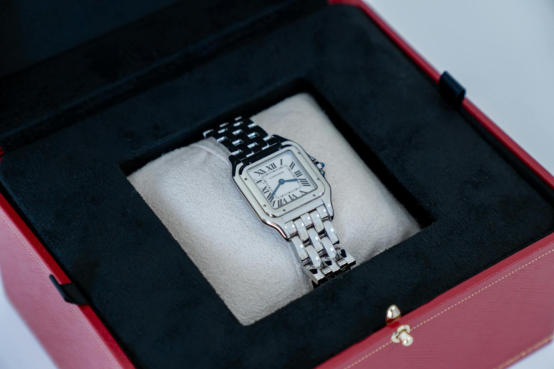 A sophisticated silver watch elegantly displayed in a premium black and red box, exuding luxury and style.